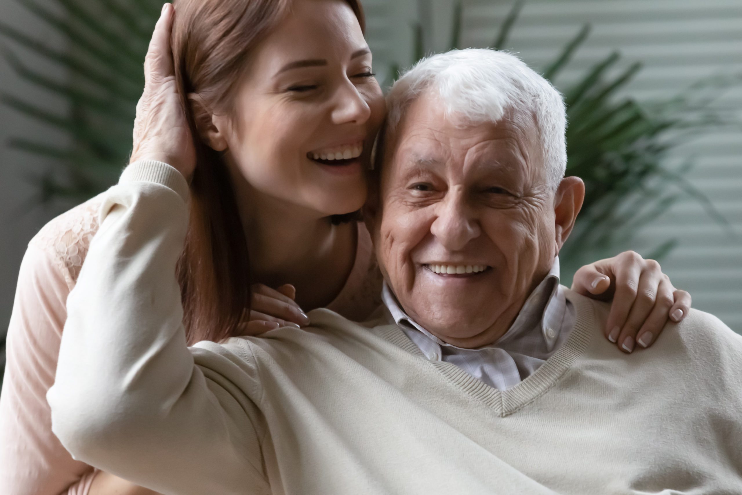 Close up loving elderly father stroking overjoyed daughter head