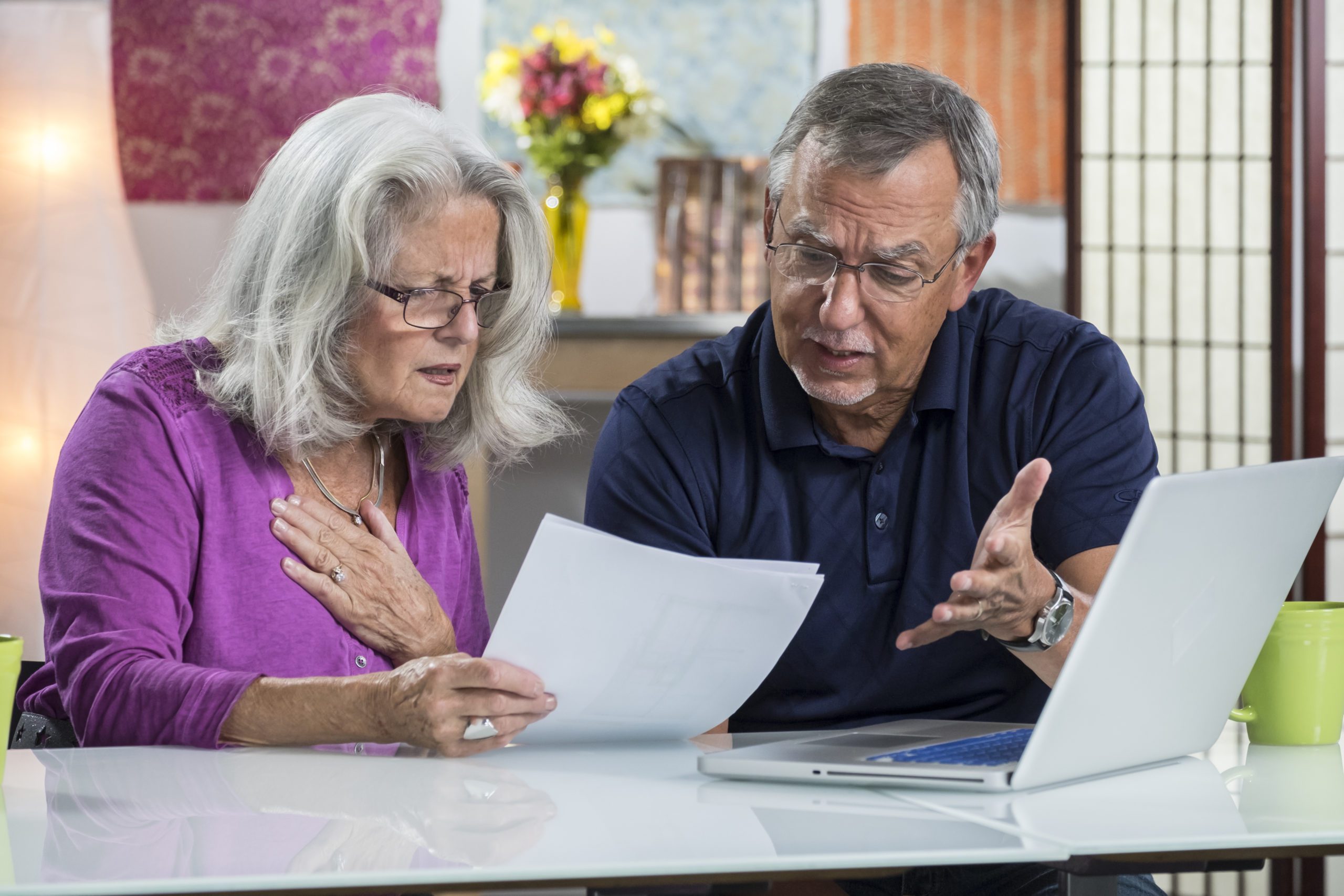 A senior aged couple looking at their bills